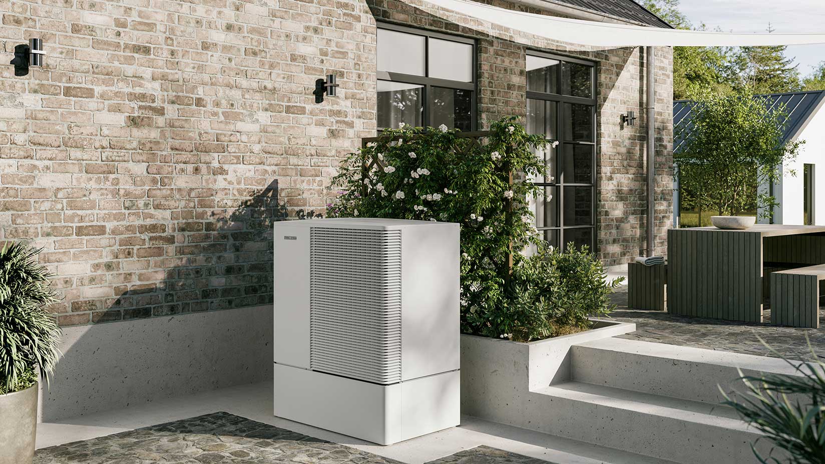 Außenaufgestellte Wärmepumpe steht vor dem Haus